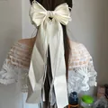 Elegante grande fermaglio per capelli con fiocco in raso crema e nastri lunghi da donna - Stile Filo Overlock (N. 60) / Bianco avorio