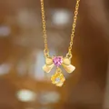 Elegante Goldhalskette mit einer rosa Herz-Schleife und einem Blumenanhänger-Detail - Rosa Strass Schleife Blume Halskette (9409)