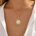 Close-up detail of a gold sun and moon pendant necklace with crystals worn by a model - Cross Chain Sunflower Necklace / Gold