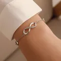Elegant silver infinity symbol chain bracelet featuring shimmering crystals on a wrist. - Rhinestone Infinity Symbol (White Gold Plated 1792)