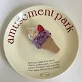 Gros plan d'une jolie pince à cheveux en forme de cornet de glace violet sur une assiette - 10.6cmx5cm / Glace à la Fraise