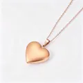 Detailaufnahme eines herzförmigen Medaillon-Anhängers in poliertem Roségold-Finish - Glatter Herz-Medaillon-Anhänger / Mit Aufhängeschlaufe und Flacher Kreuzkette / Roségold