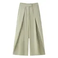 Detail shot of light olive wide-leg trousers featuring elegant front pleats. - Olive Green