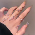 Vista dettagliata di un elegante bracciale a catena per dita in oro con foglie di zircone viola - Anello da Dito Avvolgente Zirconia Viola (DZ-137)