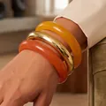 Chic set of three acrylic and gold metallic bangles in yellow and orange tones - Rounded Translucent Bangle Set (6788502) / Three-Piece Set / Gold/Amber Yellow/Coral Orange