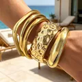 Chunky gold-tone acrylic bangle set with irregular hammered and smooth finishes. - Hammered Irregular Open Bangle Set (6787501) / Four-Piece Set / Gold
