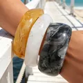 Set of three acrylic chunky bangles in amber, white, and black marble patterns. - Irregular Wide Bangle 3-Piece Set (6788101) / Set of 3 / Amber Marble White Ink Black Combo