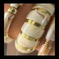 Macro detail of acrylic resin bracelet featuring elegant gold-toned metallic spacers - Irregular Block Open Bangle Set (6644201HB) / Three-Piece Set / Milky White/Gold
