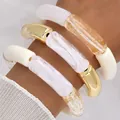 Chunky acrylic tube bead bracelet set featuring gold foil and white marble patterns on wrist - Tubular Curved Bead Bangle Set (6795601HB) / Three-Piece Set / White/Grey Marble/Transparent Gold Foil/Gold