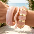 Chunky pink marble acrylic bangles set with elegant gold metal accents on a wrist - Irregular Wave Bangle 3-Piece Set (6776701) / Pink Marble Pattern