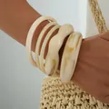 Stylish cream acrylic chunky bangle set with irregular design shown on a model wrist - Irregular Acrylic Bangle Set (6795301HB) / Beige and Amber Combo