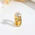 Macro detail of a golden double-layered ring with pear-shaped cubic zirconia stone. - US 7 / Pear Stone Double Loop / Gold
