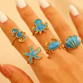 Set di 5 anelli regolabili dorati a tema oceano con creature marine in smalto blu - Set Serie Biologica Oceano Blu
