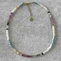 Detailansicht einer bunten Naturstein-Perlenkette mit elegantem goldenem Herzanhänger - Rosa/Blau-Mix