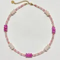 Nahaufnahme einer Perlenkette aus rosa und magentafarbenen Natursteinen mit Goldverschluss - Magenta/Hellrosa