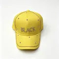 Primo piano di un vivace cappellino da baseball giallo con scritte 'BLACK' in strass luccicanti - Adulto, Circonferenza del cappello 58cm regolabile / Vestibilità regolare / Giallo