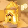 Charming miniature resin Christmas house featuring warm LED glow and faux snow details - Style A