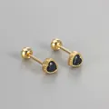 Close-up of heart-shaped gold stud earrings with black zirconia and screw back closures - Gold / Black