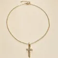 Detailed close-up of gold-tone cross pendant necklace with sparkling pavé rhinestones. - Cross Necklace / Gold