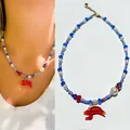 Vue détaillée d'un collier de perles fait main avec pendentif homard en verre rouge. - Collier Homard Rouge Oeil du Mal