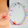 Detailed view of a colorful beaded necklace featuring a whimsical red glass lobster pendant. - Colorful Dragonfly Necklace / 38+5cm