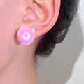 Pink fuzzy pom-pom earring featuring a centered evil eye zircon design shown on ear - Monster Eyeball Style / 12 Bright Silver Pink (N-527)