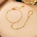 Nahaufnahme der vergoldeten Edelstahl-Handkette mit drei funkelnden Zirkonia-Akzenten - Drei Weiße Strasssteine Handkette (Gold)
