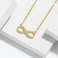 Detailed view of a gold infinity necklace with shimmering cubic zirconia stones. - Necklace / Gold