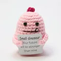 Handmade pink crochet dinosaur doll holding an inspirational positive energy card - Pink Dinosaur