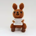 Handmade brown crochet kangaroo doll holding a tiny white positive motivational message card - Dark Brown Long Tail Kangaroo