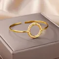 Detailopname van gouden roestvrijstalen open armband met gehamerd cirkelontwerp - Ronde Decoratie Gehamerd Stijl (B1267G)