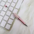 Eleganter rosa Perlenkugelschreiber mit Strasssteinen auf einer weißen Tastatur. - Perlenstil / Rosa
