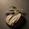 Dettaglio di una statuina di colibrì in ottone massiccio antico su una base in pietra testurizzata - Uccello in volo