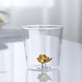 Close-up detail of a 3D amber hedgehog animal figurine inside a transparent glass drink cup - Hedgehog