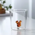 Detail of transparent glass cup featuring a 3D amber squirrel figurine inside the base - Squirrel