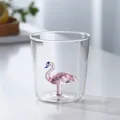 Detailed close-up view of a cute 3D pink glass flamingo figurine inside a clear drinking cup - Flamingo