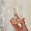 Detail of clear glass cup featuring a delicate 3D pink rose sculpture at the bottom - Rose