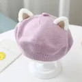Close-up of children's knitted beret featuring plush cat ear details and soft pink knit. - One Size 46-51cm / Purple