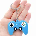 Close-up of a blue silicone game controller keychain held in a person's hand - Simulation Gamepad / Blue