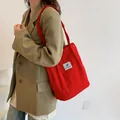 Borsa tote in velluto a coste rosso con etichetta indossata da modella in blazer - Rosso