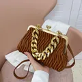 Elegant brown pleated shell bag featuring chunky gold chain handle and kiss-lock closure - Brown