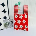 Full view of a red knitted bag with flower motifs against a minimalist white background - Flower Red