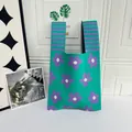 Detailed macro view of the green and purple floral pattern on this knitted vest tote bag - Green with Flower