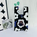 Detailed view of black knit tote bag with large white floral patterns and central character. - Little Girl Black