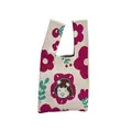 Detail of a knitted vest handbag featuring magenta flowers and a cute cartoon face - Little Girl Beige