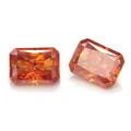Macro view of two radiant cut vibrant orange moissanite gemstones on a white background - 5*7mm 1ct + GRA Girdle Inscription / Fanta Bottle