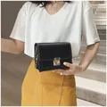 Elegante zwarte kleine vierkante crossbodytas met gouden ketting getoond op een model - Zwart