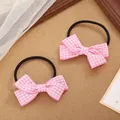 Detail shot of two sweet pink and white gingham bow hair ties on a rustic textured surface - Pink and White Plaid