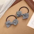 Detailed view of two checkered bow-knot hair ties with black and white gingham pattern - Black White Grid