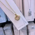 Detailed shot of a titanium steel four-leaf clover necklace with sparkling crystal inlay - Gold + White
